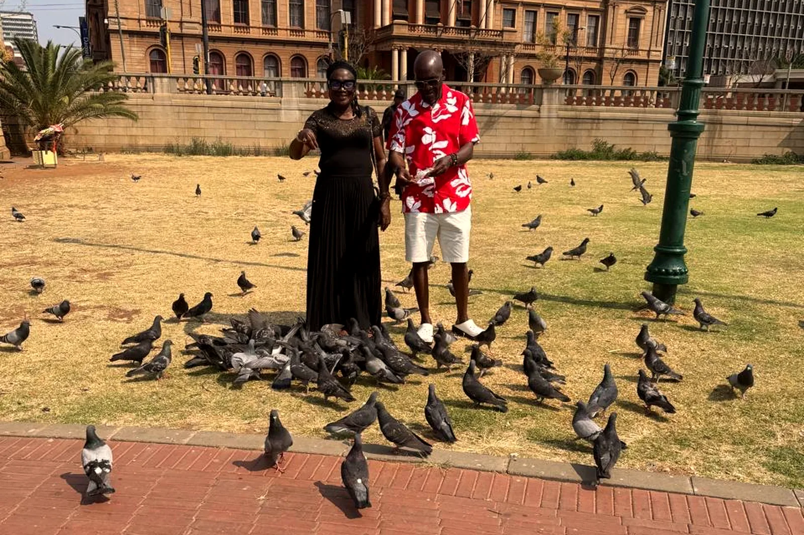 Couple feeding pigeons on the lawns of the Union Buildings in Pretoria
